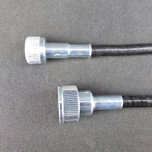 Two metal cables with knurled ends on a gray background